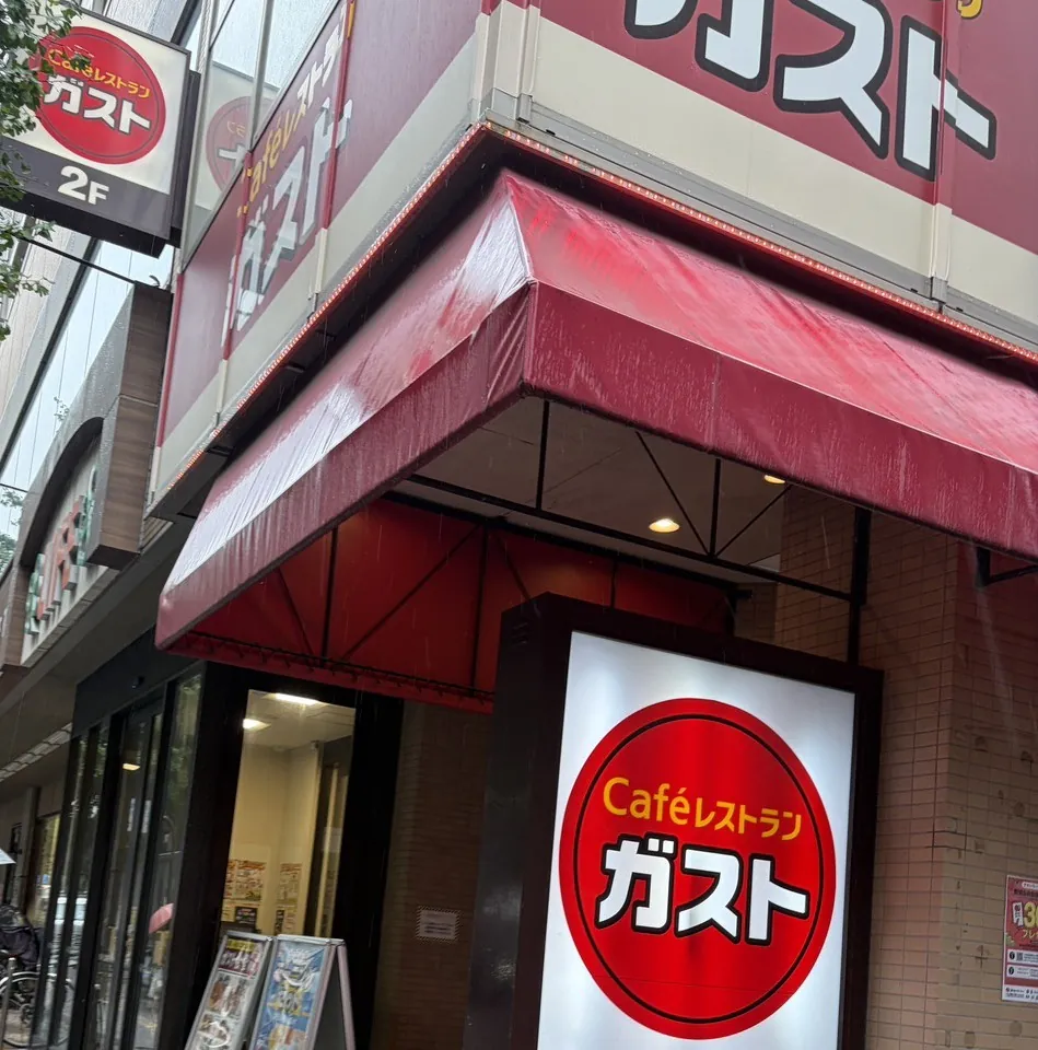 Gusto 门店外观。红色遮阳篷上方和入口旁边,有用片假名写着“ガスト”的红色圆形招牌。