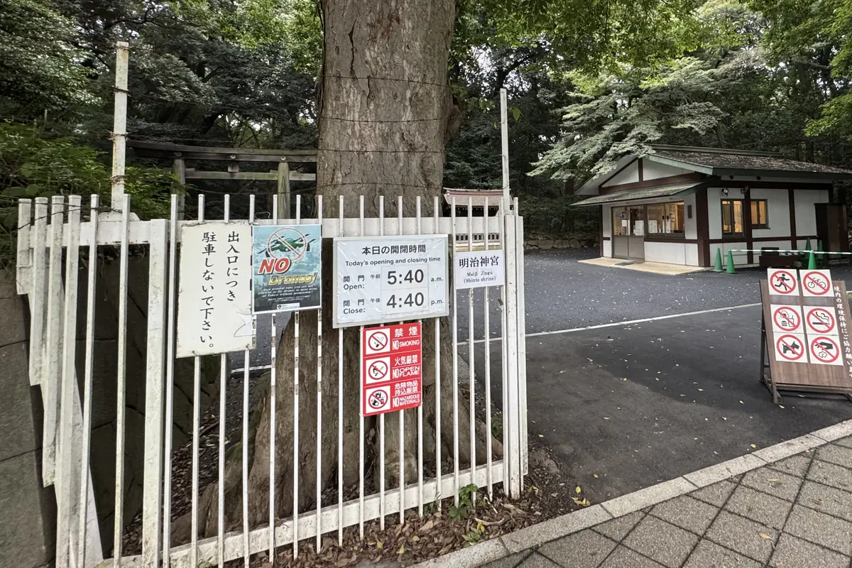 Avviso appeso alla recinzione dell'ingresso. Gli orari di apertura e di chiusura dei cancelli di quel giorno sono scritti in giapponese e in inglese. Accanto c'è il segnale di divieto di droni e, sotto, altri segnali come il divieto di fumo.