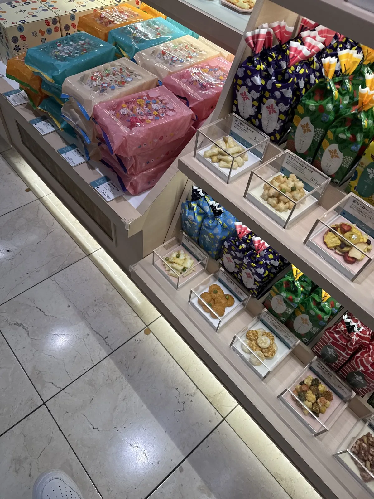Scaffale del reparto dolci al B1F. I dolci in scatola sono disposti per tipo.