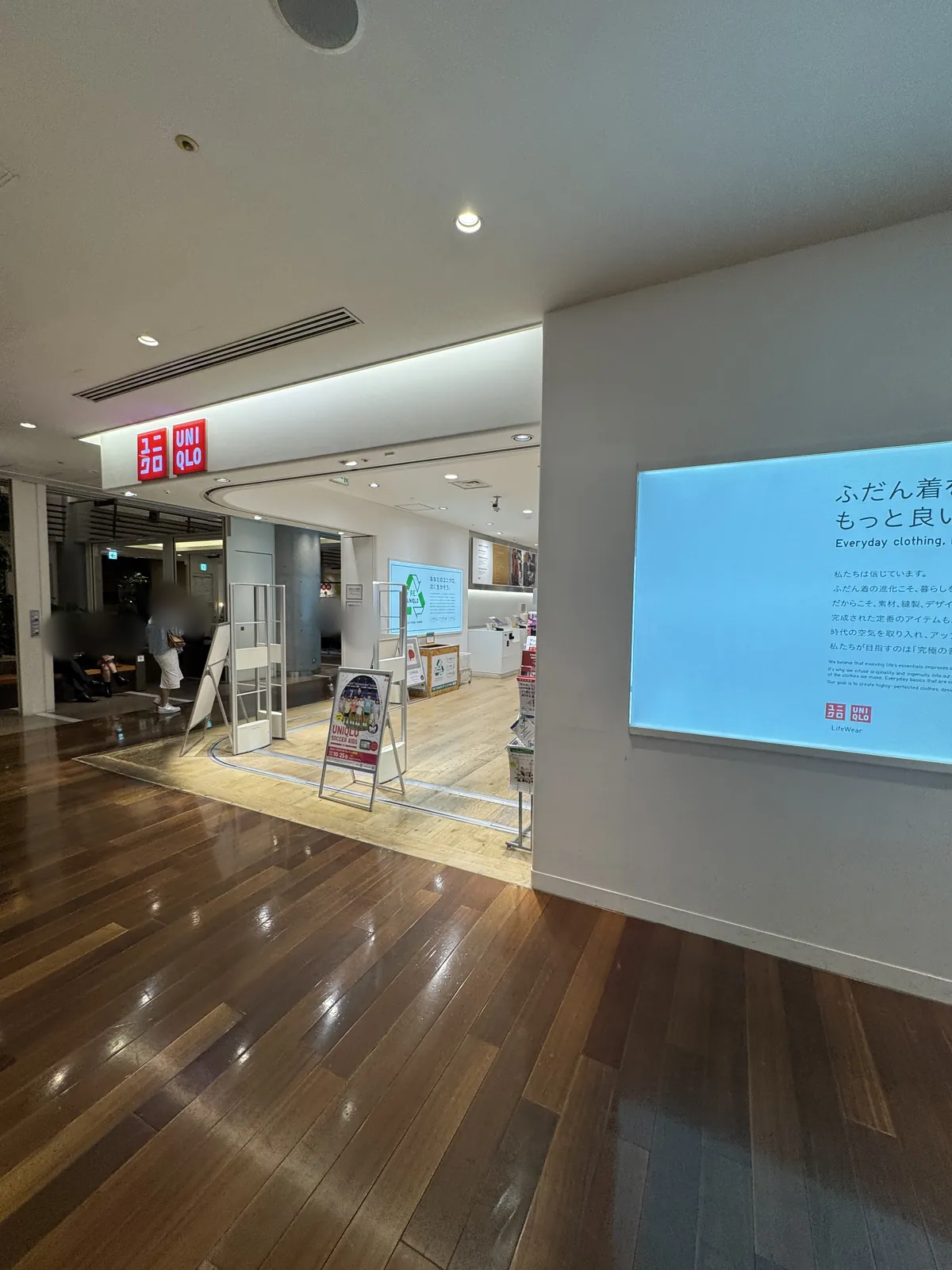 Takashimaya Times Square 12F의 통로에서 본 유니클로 입구. 입구 위에 일본어와 영어로 "UNIQLO"라고 쓰인 빨간 간판이 있다.